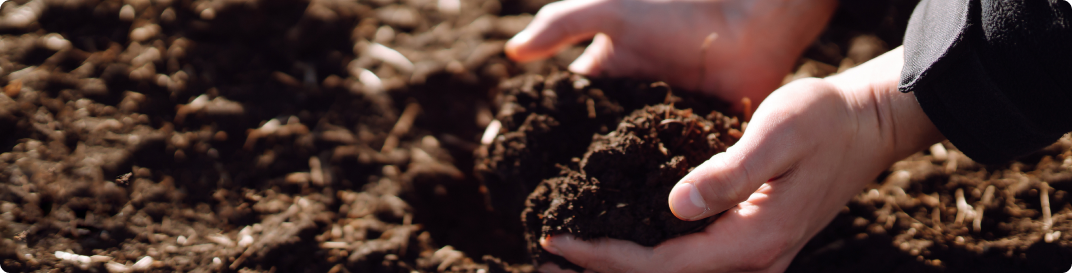 Manos trabajando con suelo y compost para aprovechar residuos orgánicos.